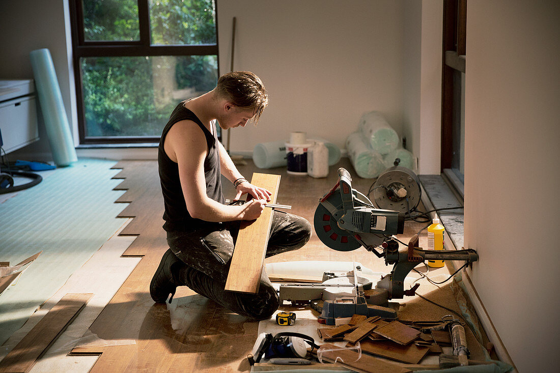 Construction worker preparing hardwood flooring