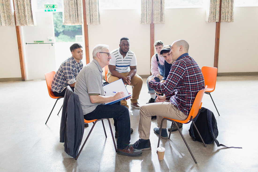 Men talking in circle in group therapy
