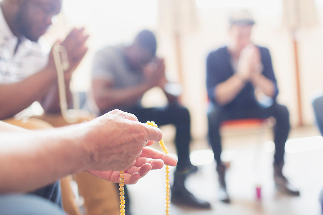 Men praying with rosaries in prayer group