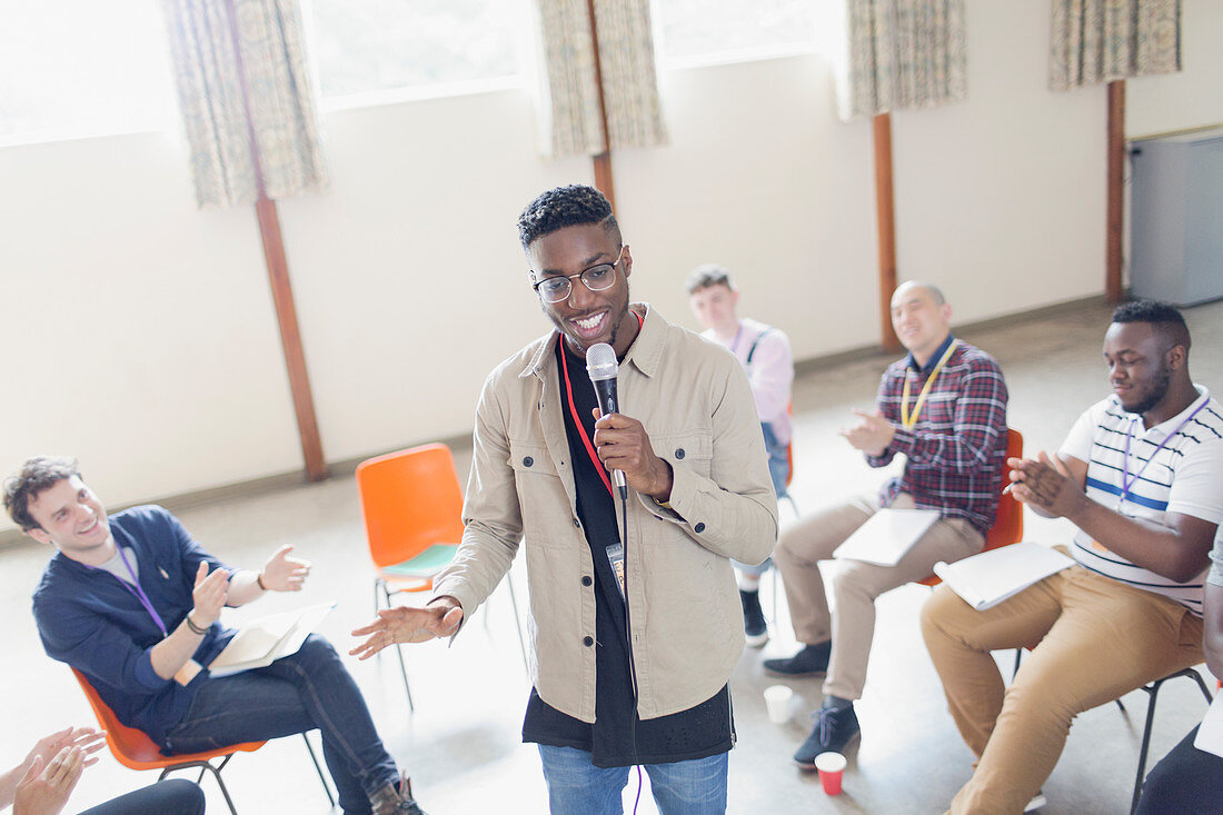 Man with microphone leading group therapy