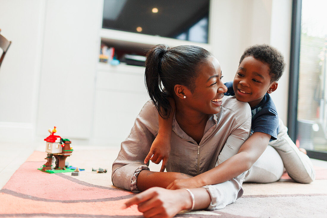 Affectionate mother and son on living room floor