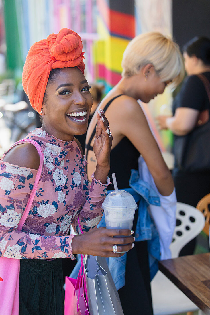 Young woman in headscarf drinking smoothie