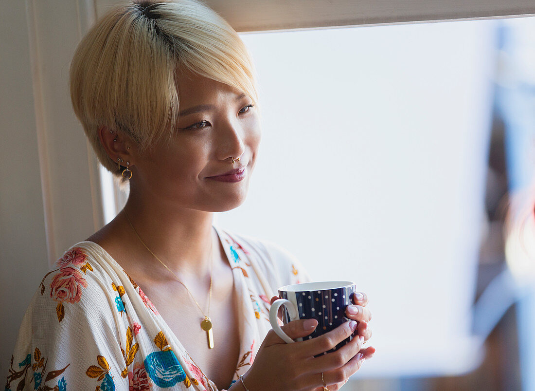 Smiling young woman drinking coffee