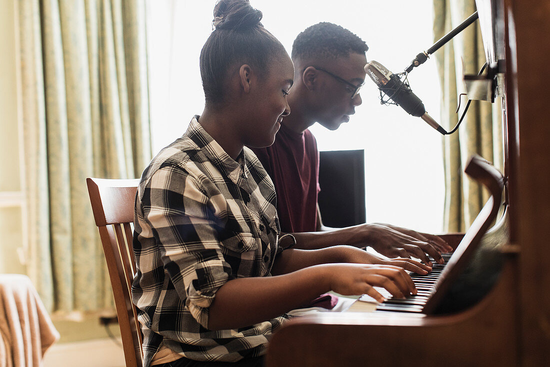 Teenage brother and sister playing piano