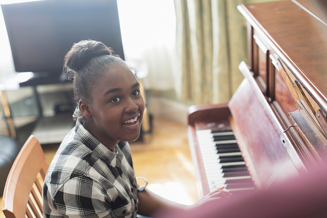 Smiling girl playing piano