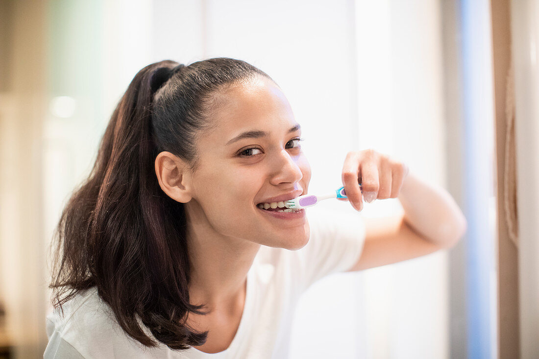 Portrait woman brushing teeth
