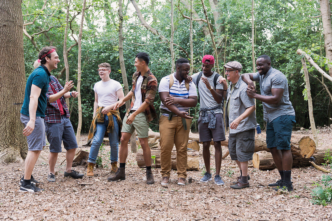 Men's group talking, hiking in woods