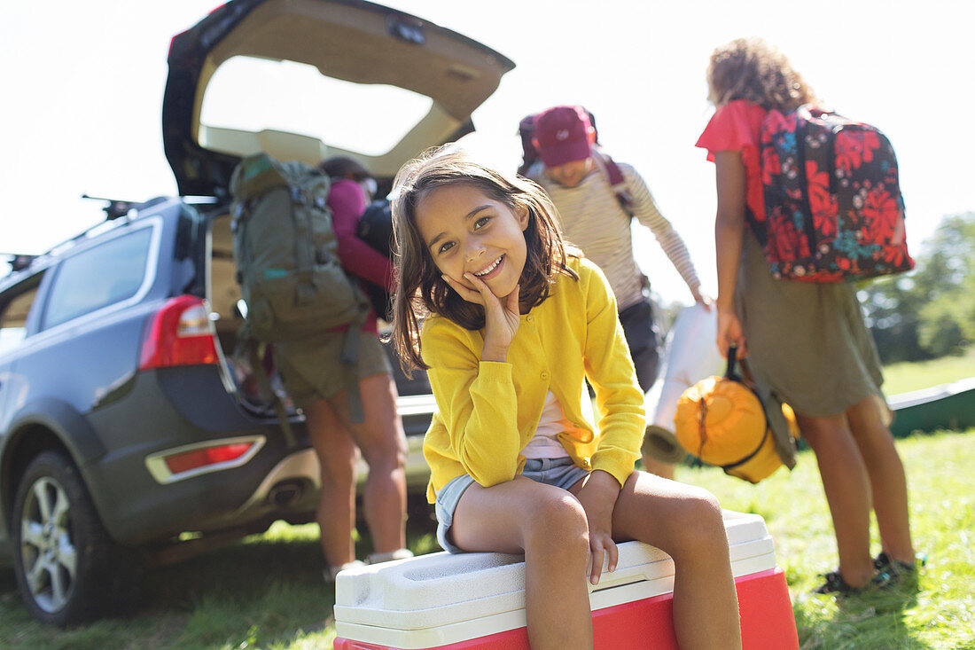 Portrait girl camping with family, unloading car