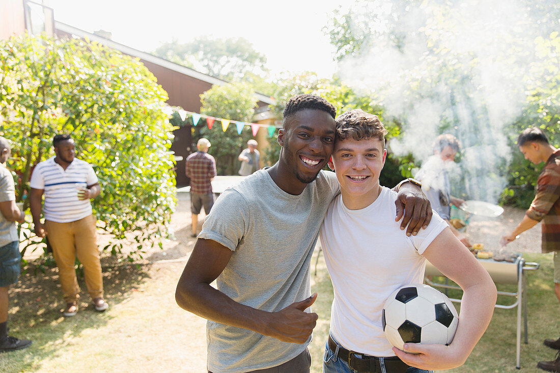 Portrait men with soccer ball enjoying backyard barbecue