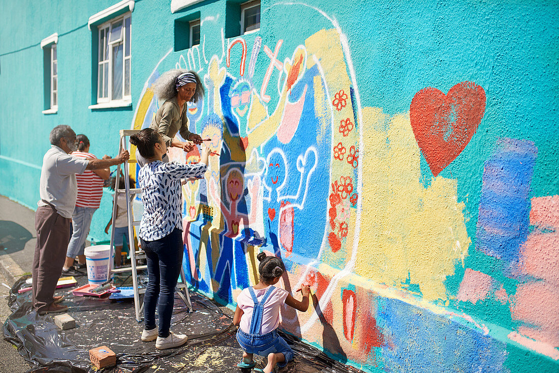 Community volunteers painting multicolour mural