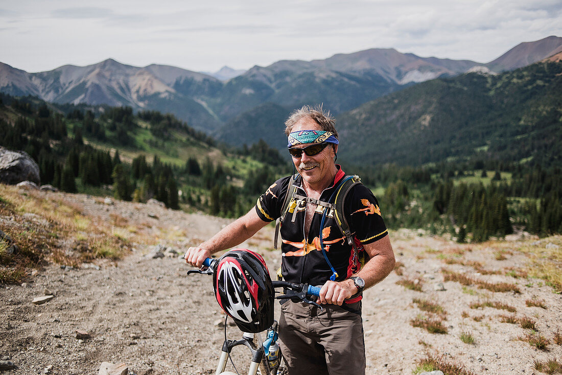 Portrait senior man mountain biking in landscape, Canada