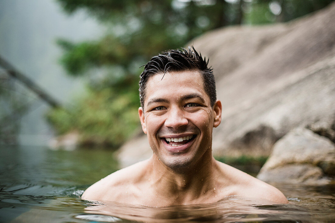 Portrait smiling, handsome man swimming in lake
