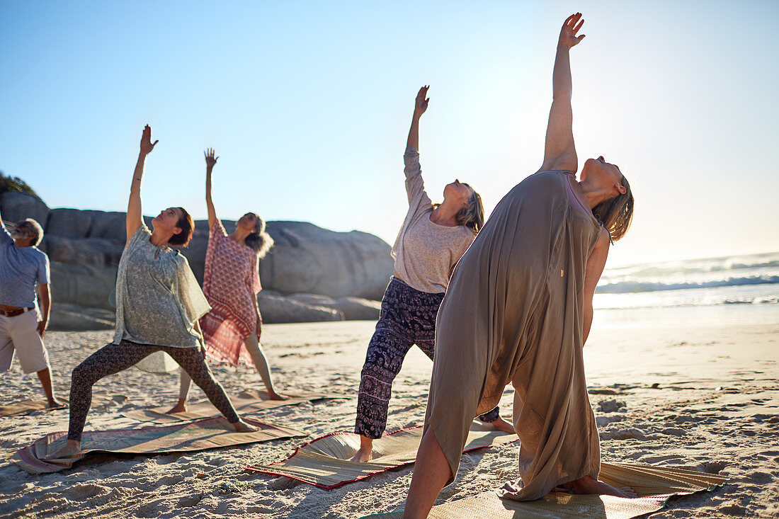 Group practicing yoga reverse warrior pose