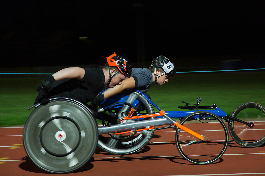 Paraplegic athletes during wheelchair race at night