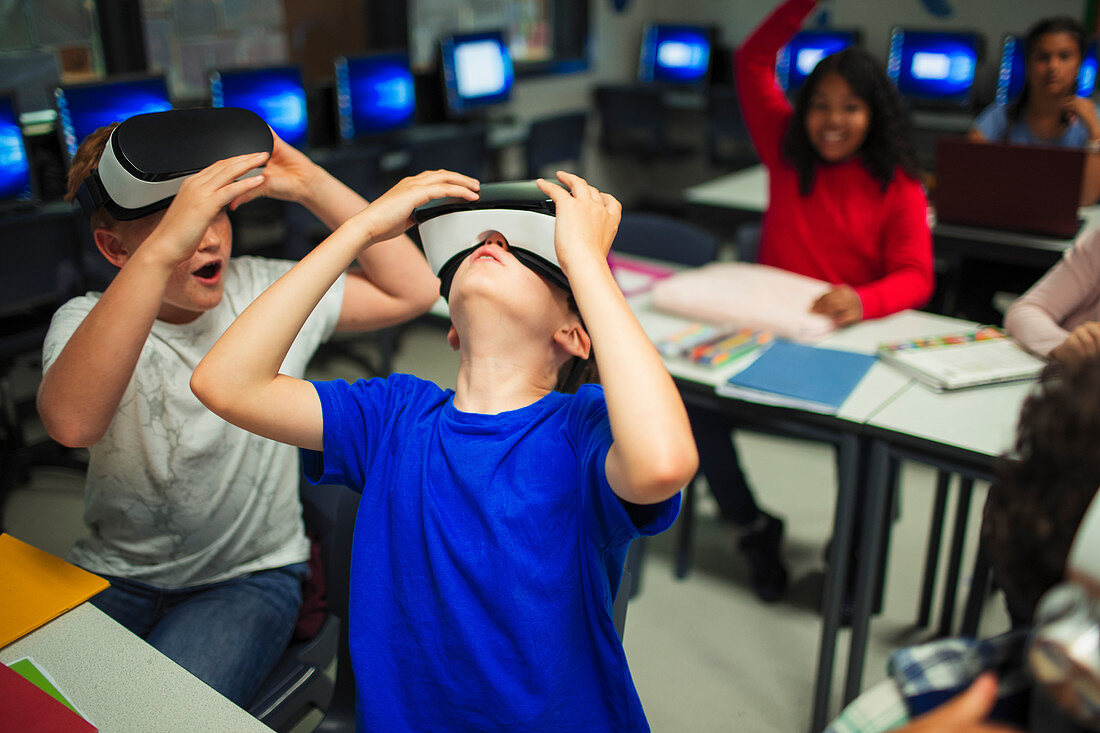 Curious school boys using virtual reality simulators