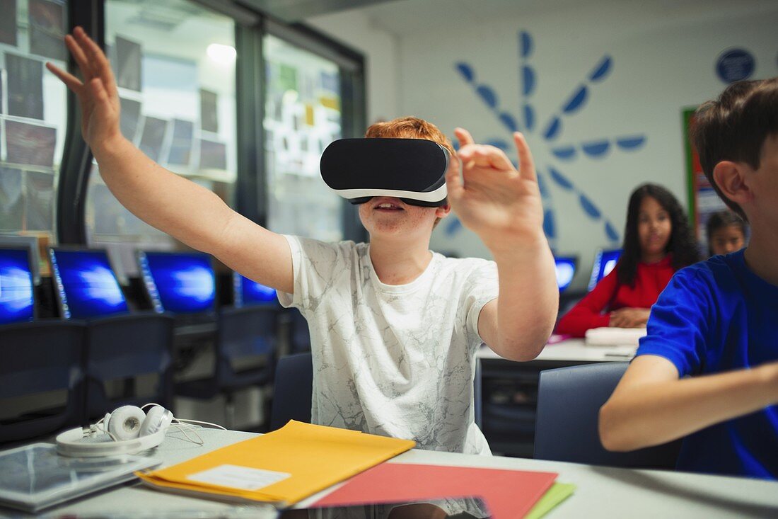 Curious school boy student using virtual reality simulator