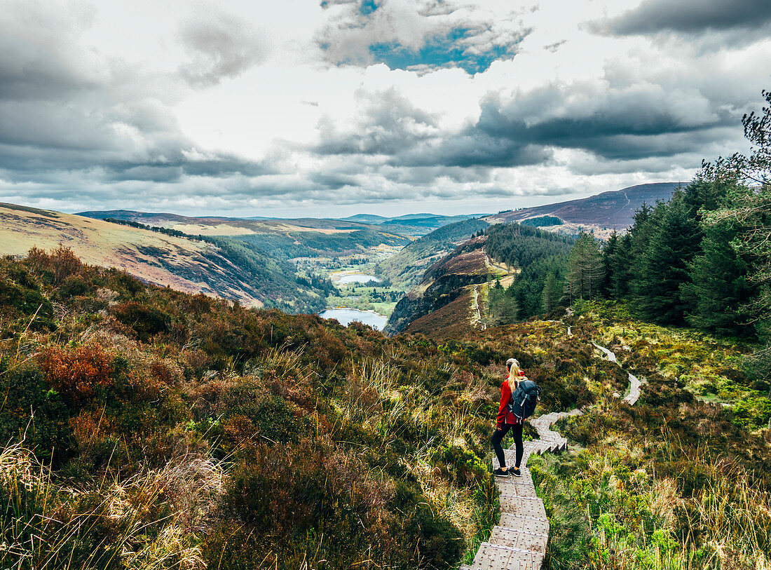 Woman hiking along idyllic mountain path, Ireland