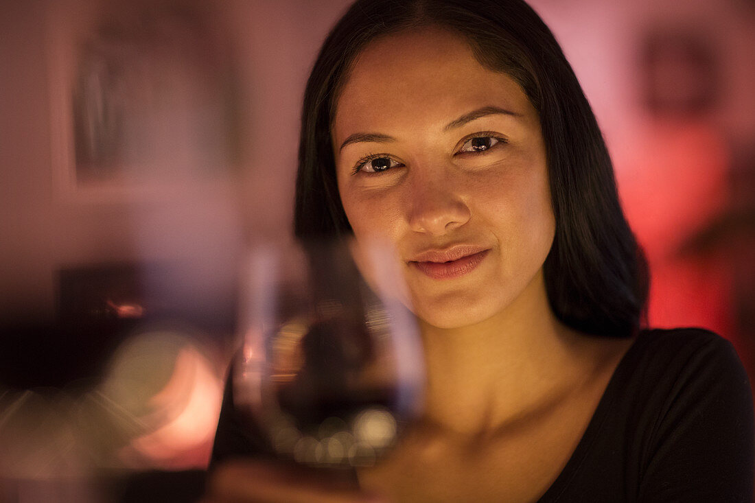 Portrait confident young woman holding wine glass