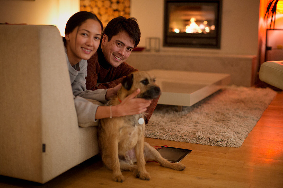Portrait happy couple with dog in living room
