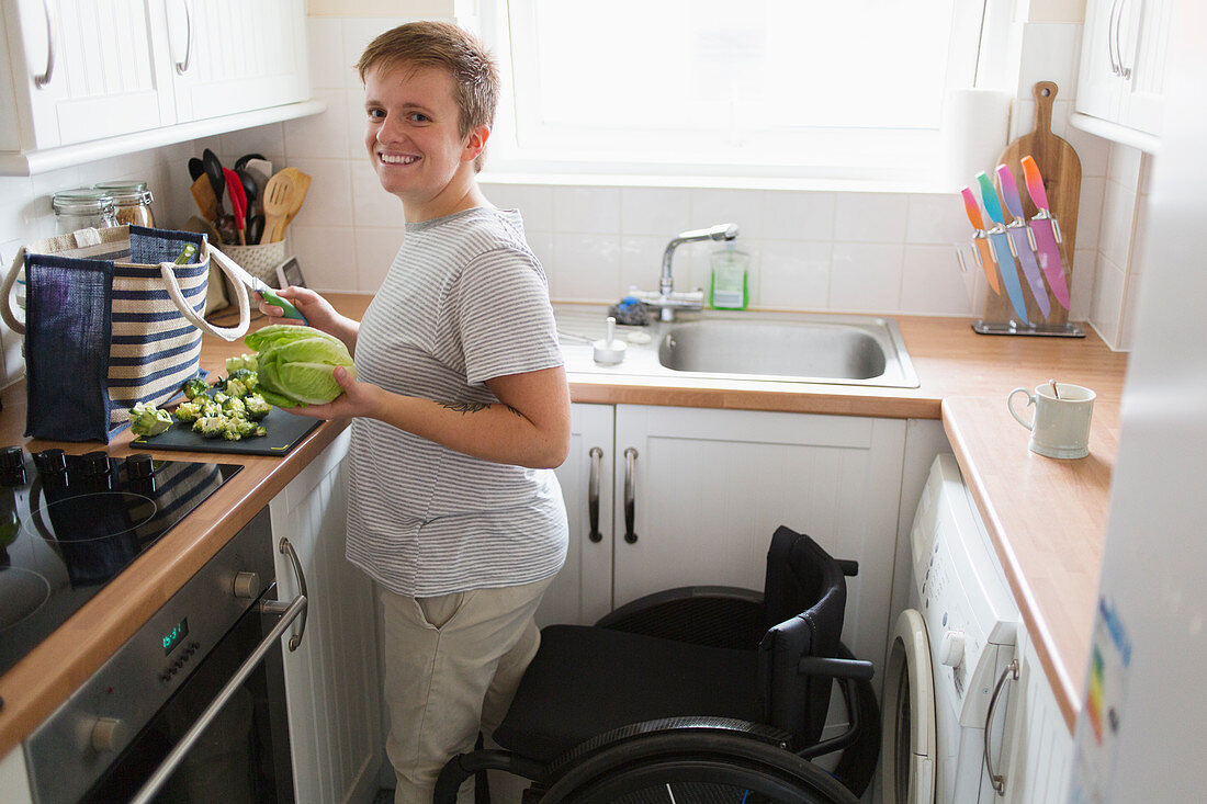 Portrait woman with wheelchair cooking