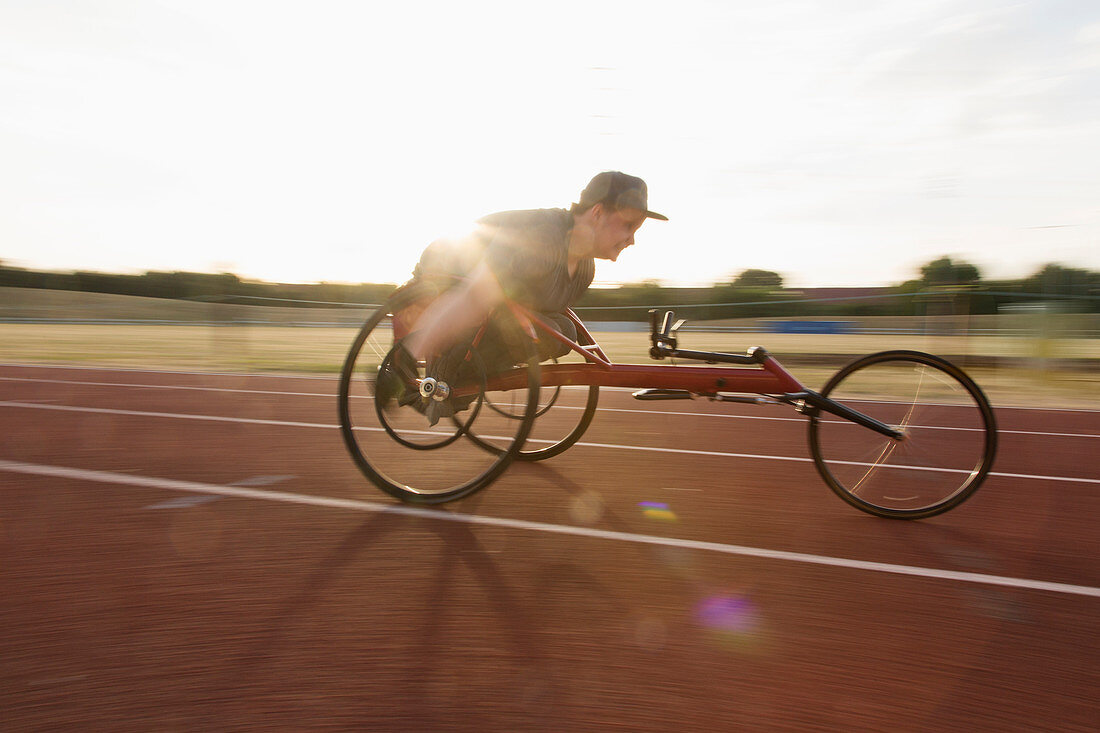 Determined teenage boy paraplegic athlete in wheelchair race