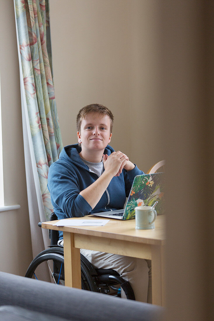 Portrait woman in wheelchair using laptop