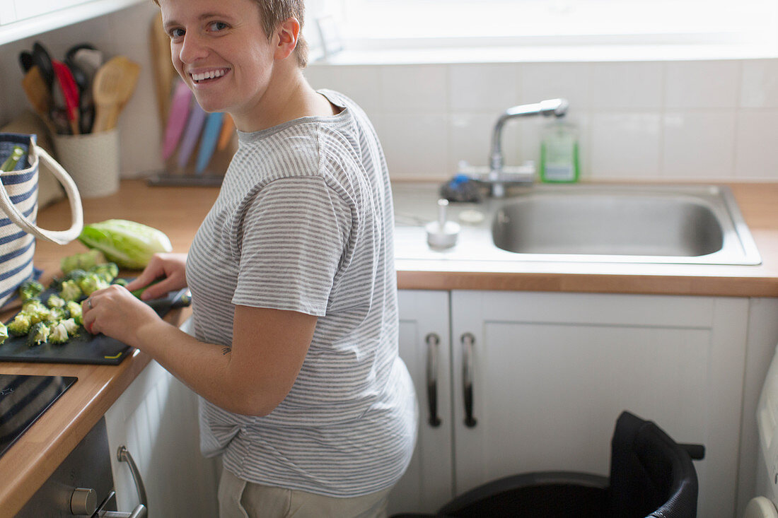 Portrait woman with wheelchair cutting vegetables