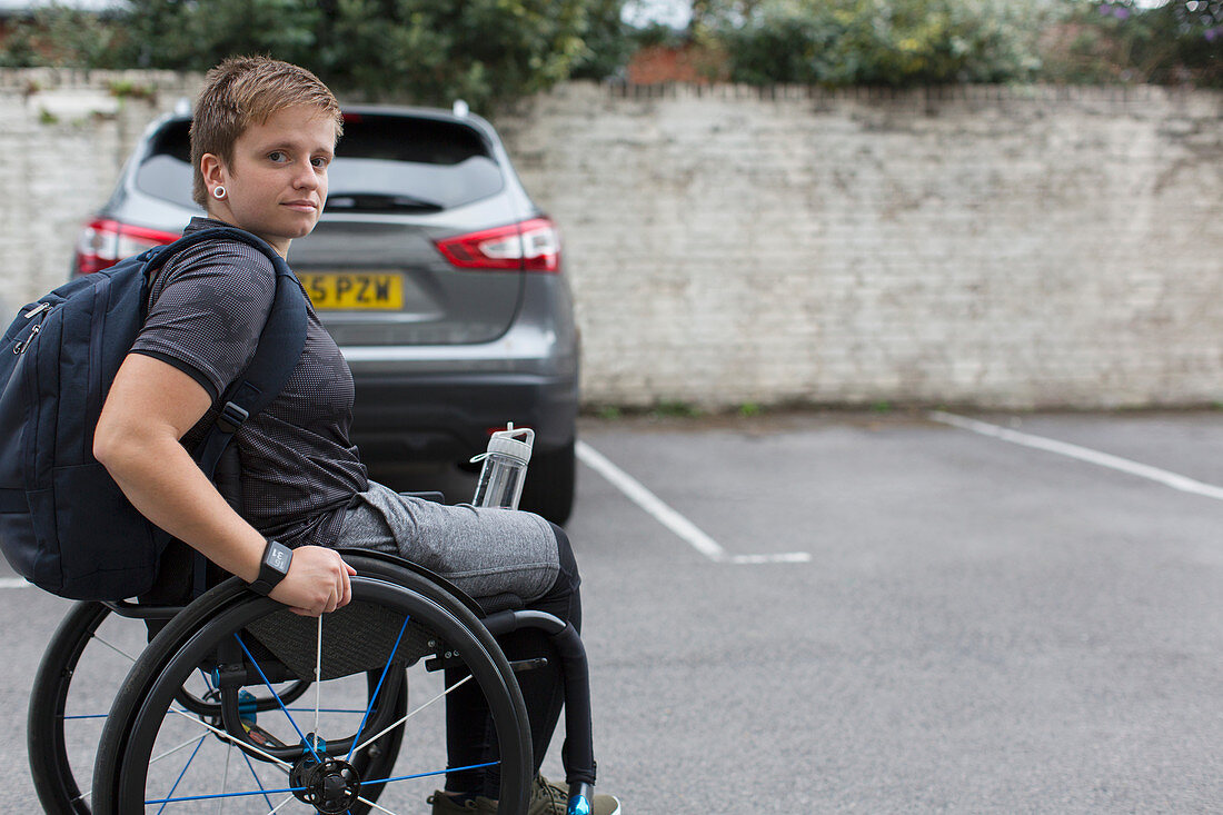 Portrait university student in wheelchair in parking lot