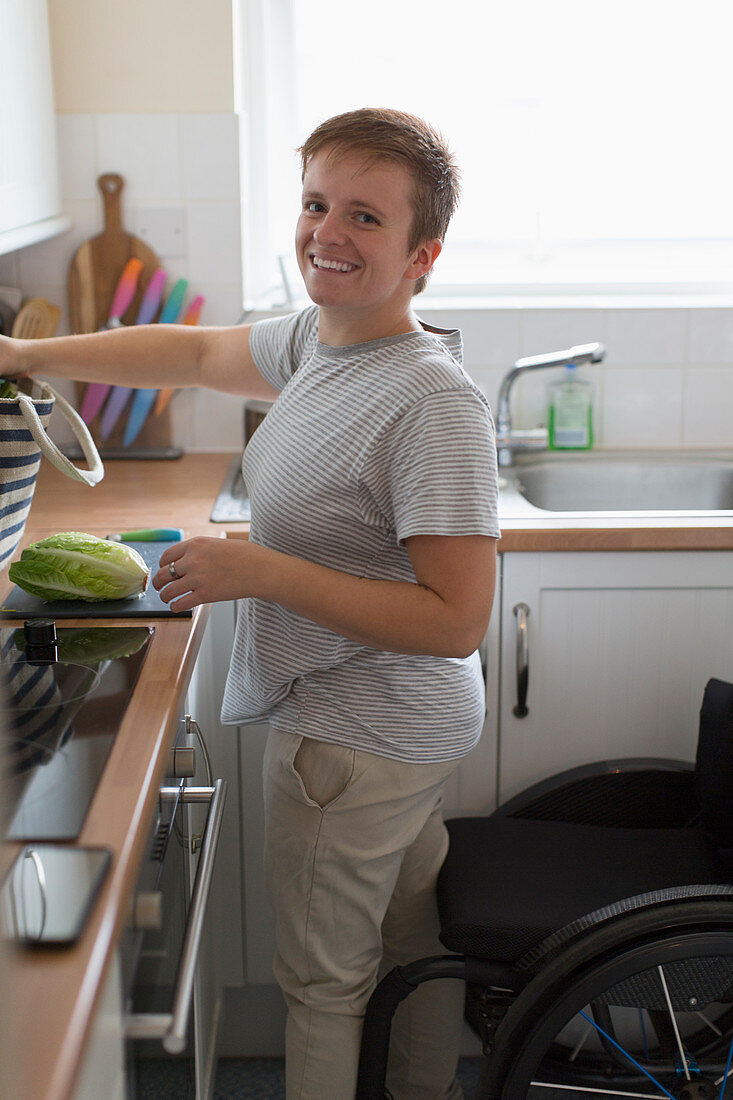 Portrait woman with wheelchair cooking