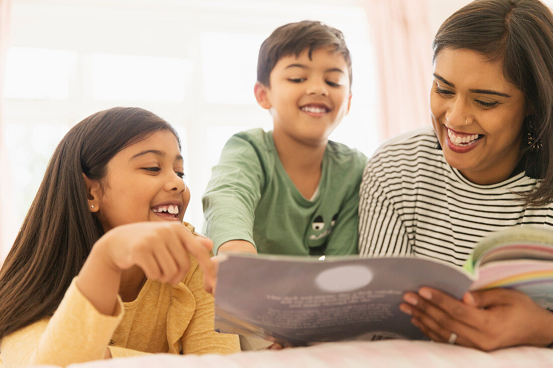 Mother and children reading book