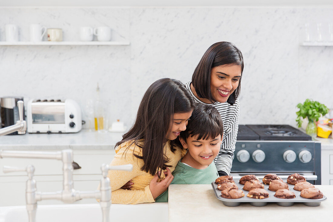 Mother and children baking chocolate muffins