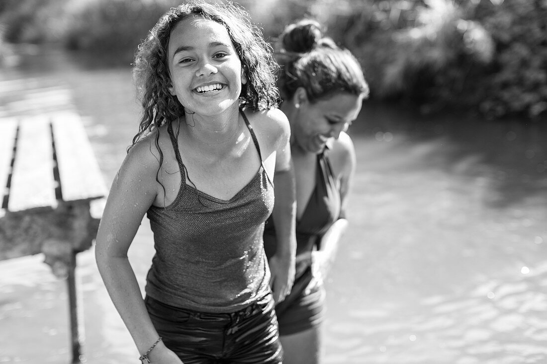 Portrait happy, carefree mother and daughter at river