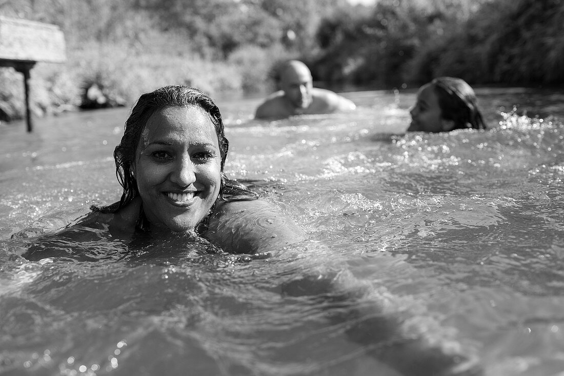 Portrait woman swimming with family in river