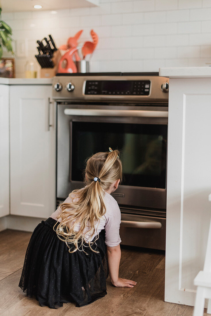 Curious girl watching oven