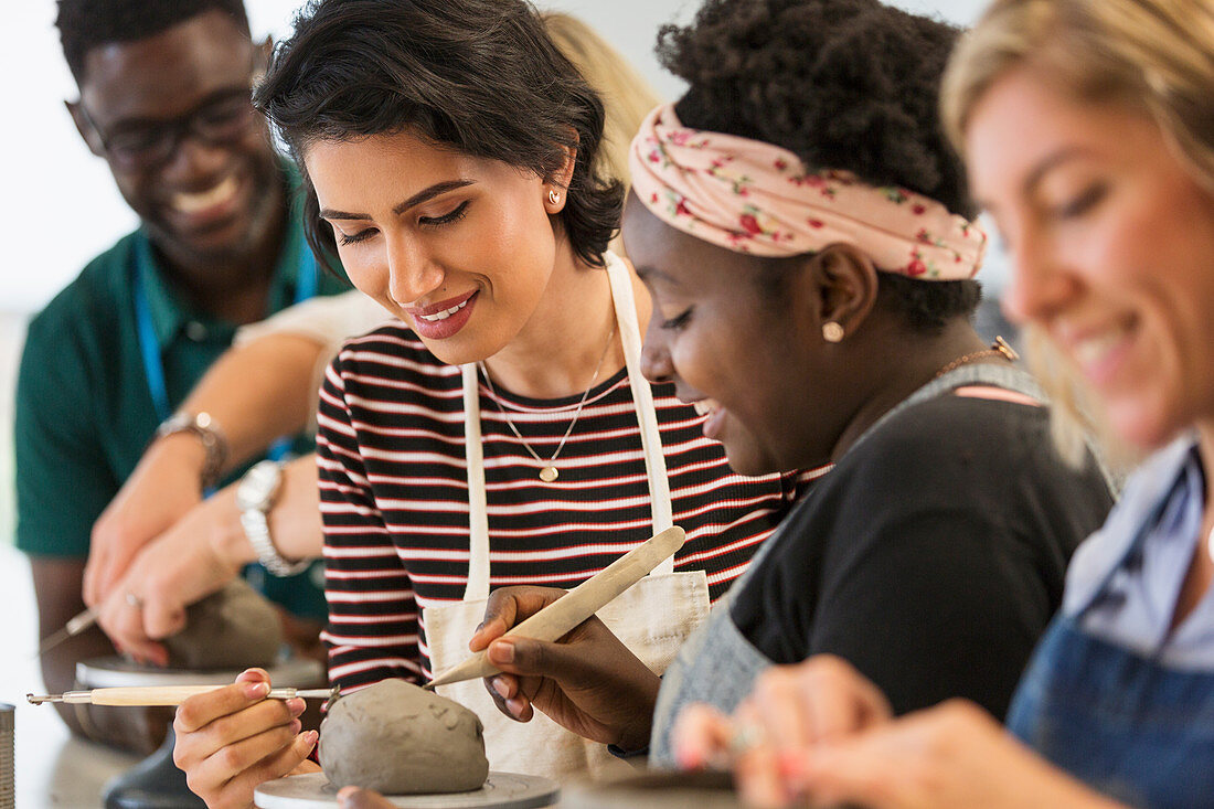 Women shaping clay in art class