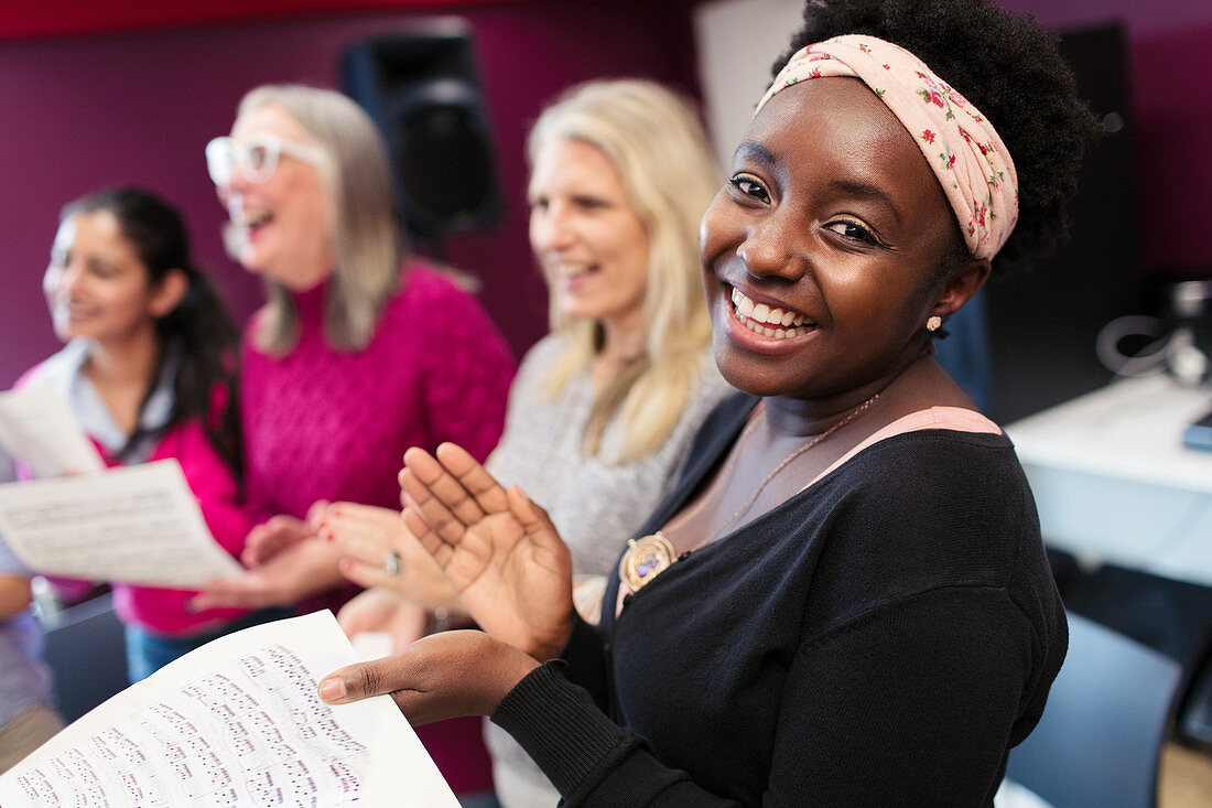 Happy woman singing in choir in music recording studio