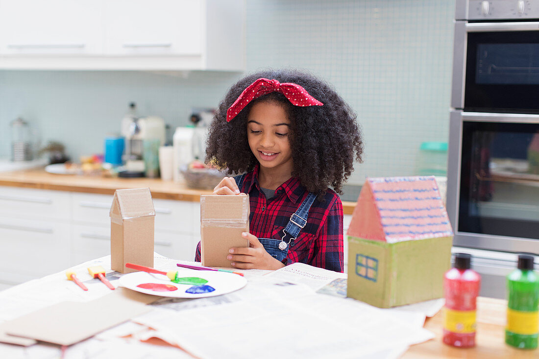 Girl painting house crafts in kitchen