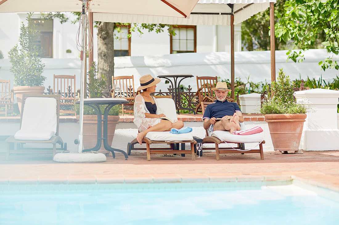 Mature couple relaxing at resort poolside