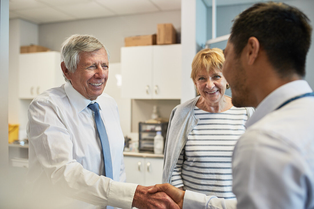 Doctor shaking hands with senior couple