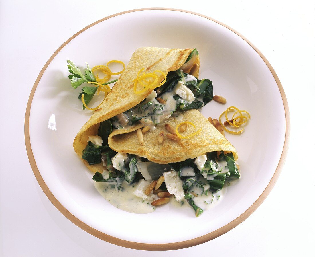 Pancakes with chard, pine nuts and cheese sauce