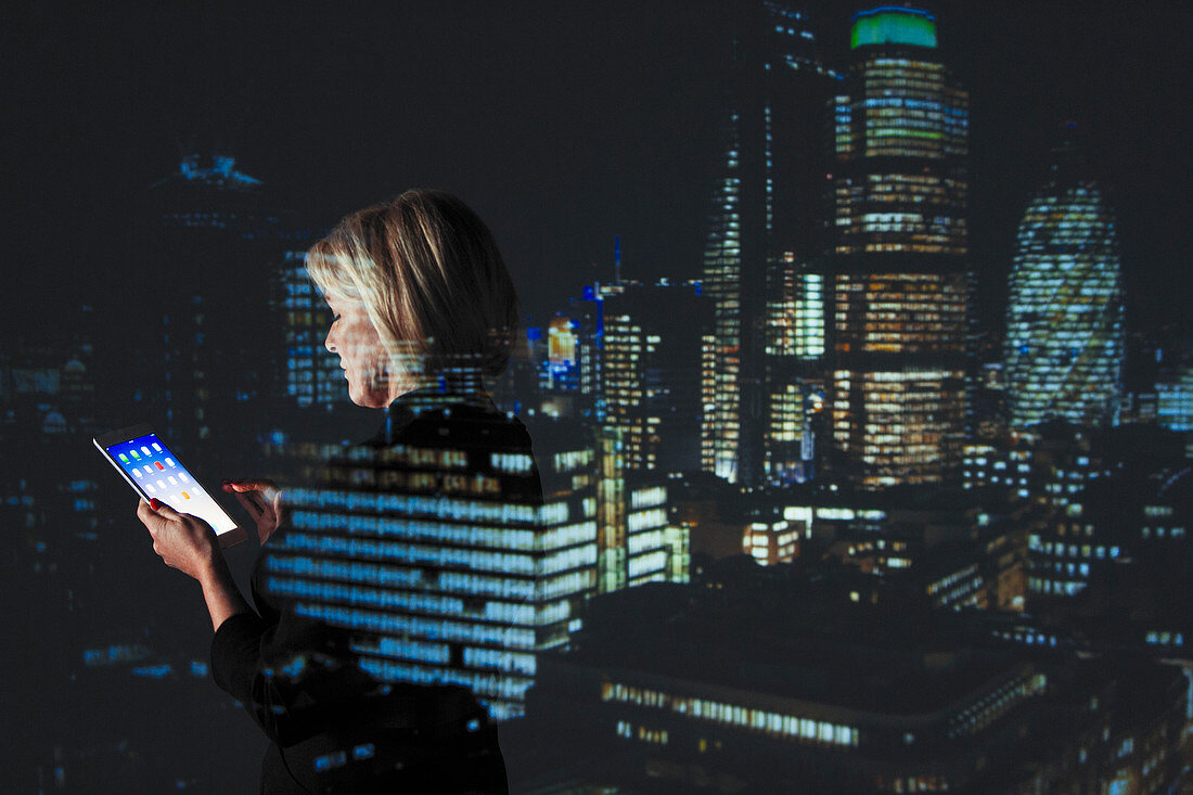 Businesswoman using digital tablet at night