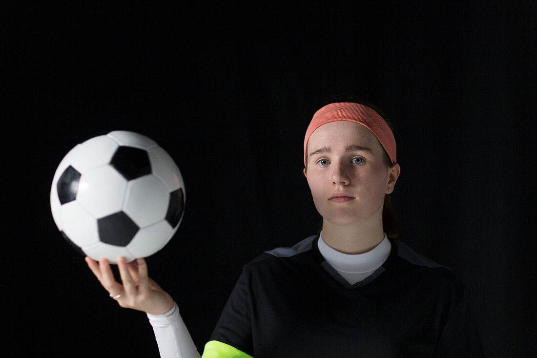 Teenage girl soccer player holding soccer ball