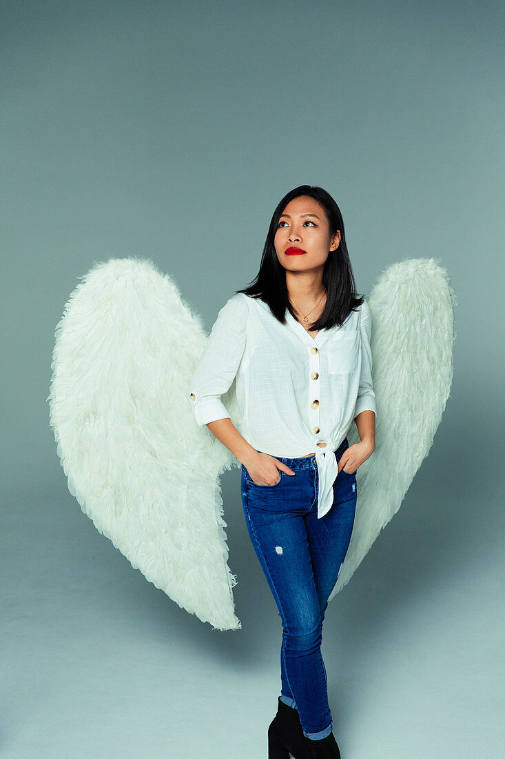 Portrait serene, thoughtful woman wearing angel wings