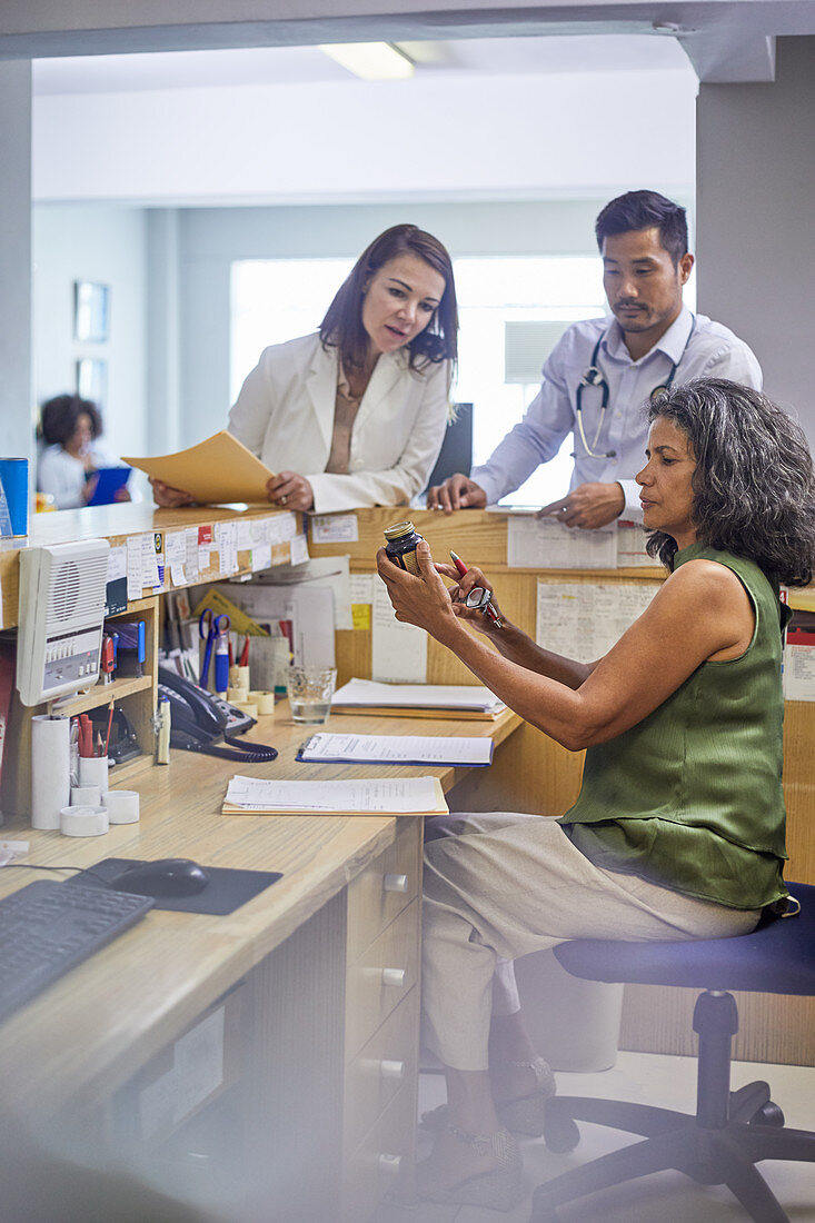 Doctors and receptionist examining medication