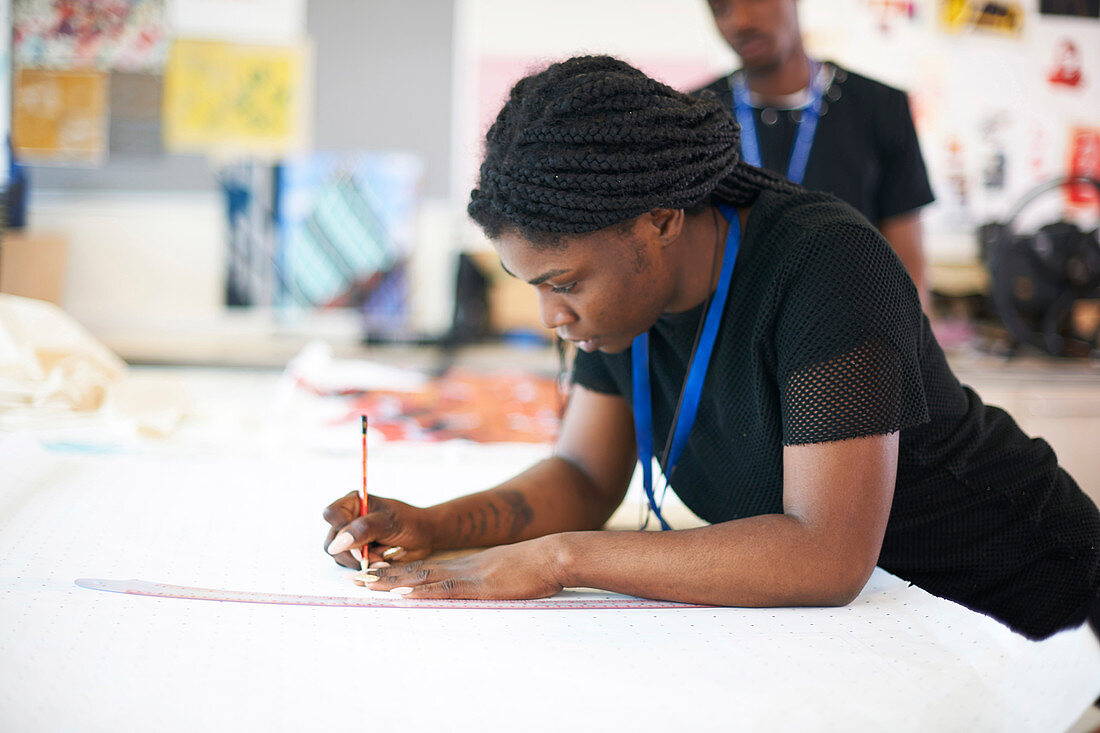 Female fashion designer drawing sewing pattern