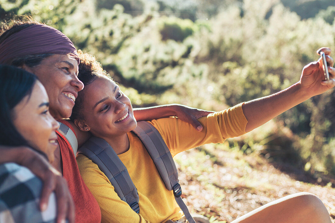 Happy mother and daughter hikers taking selfie