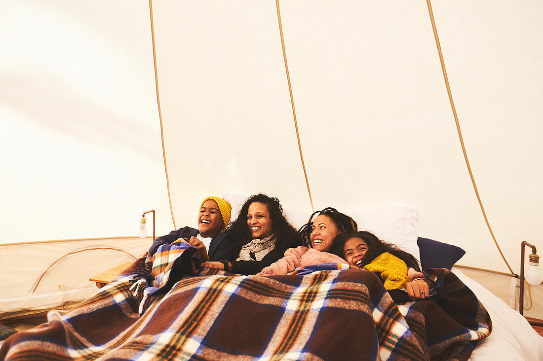 Happy lesbian couple and kids in camping yurt