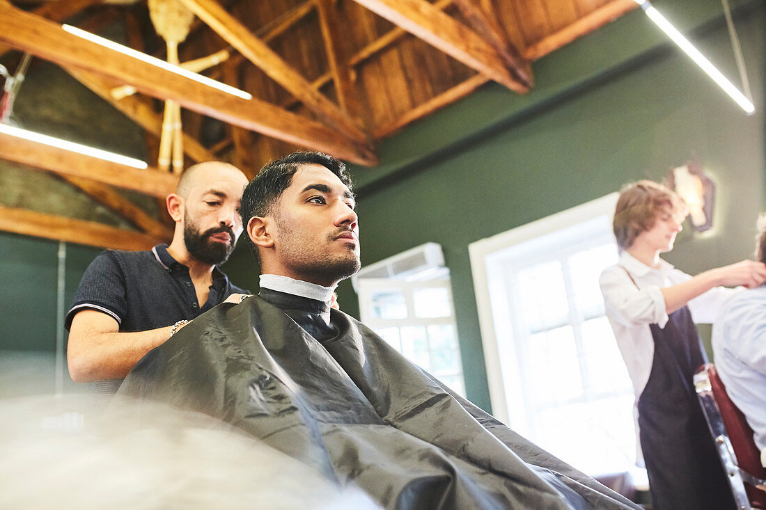 Male customer getting a haircut in barbershop