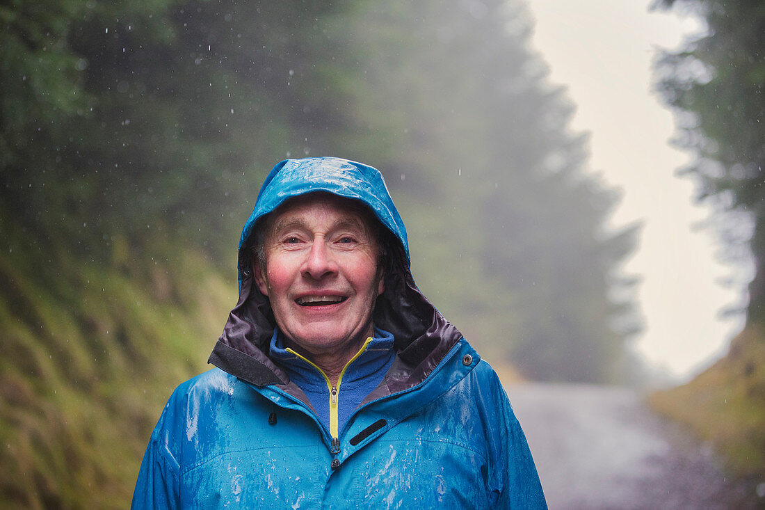 Senior man hiking in rain