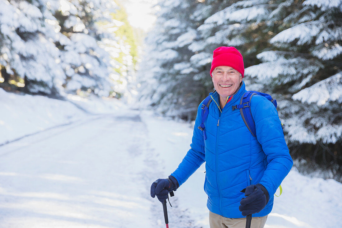 Happy senior man hiking in snow